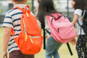 Les enfants portent un lourd sac à dos à l'école